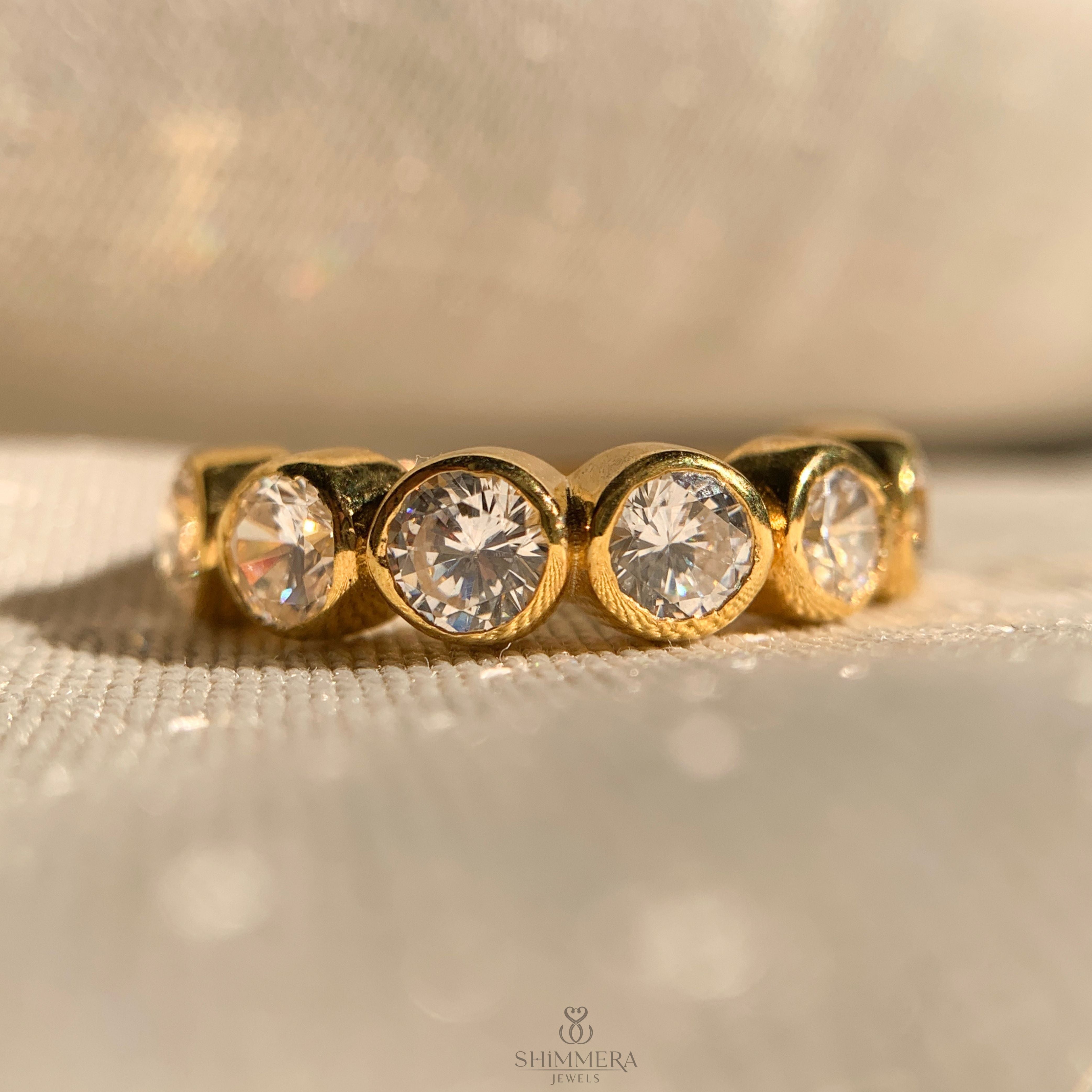 “Elegant bezel set round diamond band in polished gold for timeless style”
